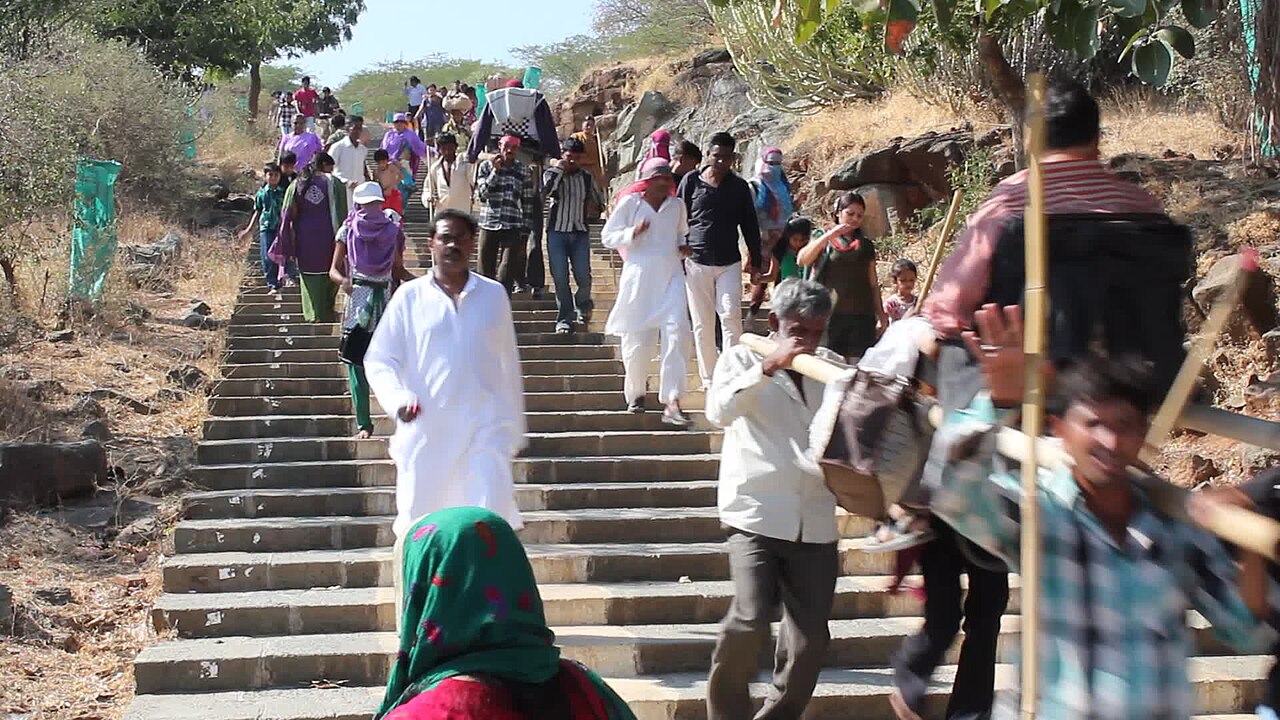 Pilgrims and doli bearers on the stone steps of Shatrunjaya hill