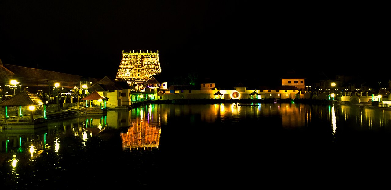 Sree Padmanabhaswamy Temple lit for Lakshadeepam, its gopuram and lamps reflected in the Padmatheertham at night