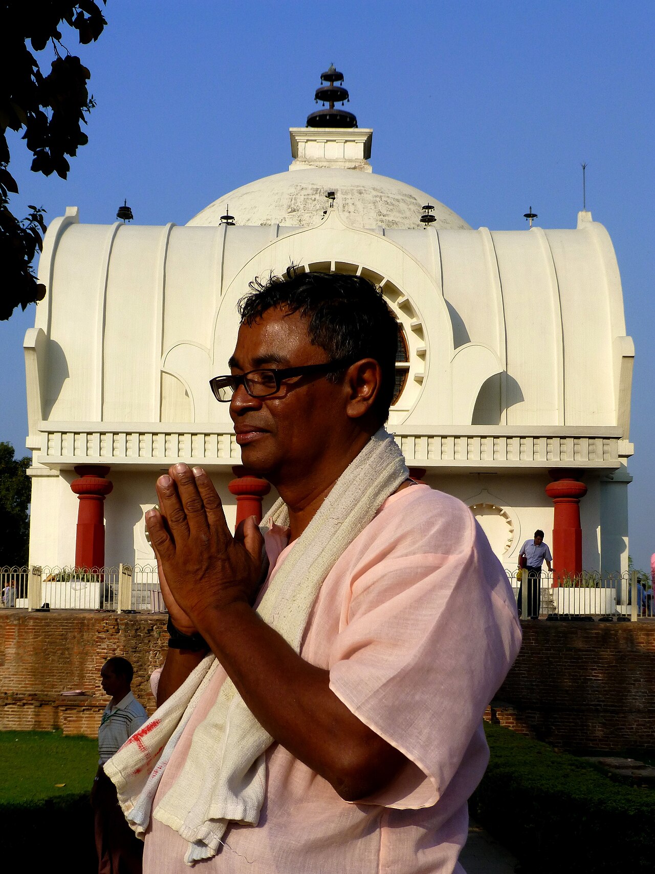 A devotee praying with folded hands before the Parinirvana Temple at Kushinagar