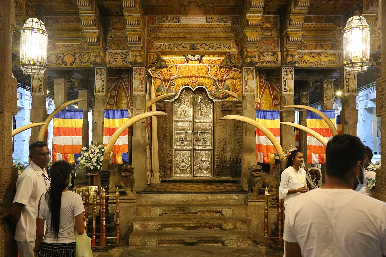 The silver-worked door of the relic shrine, framed by elephant tusks and Buddhist flags