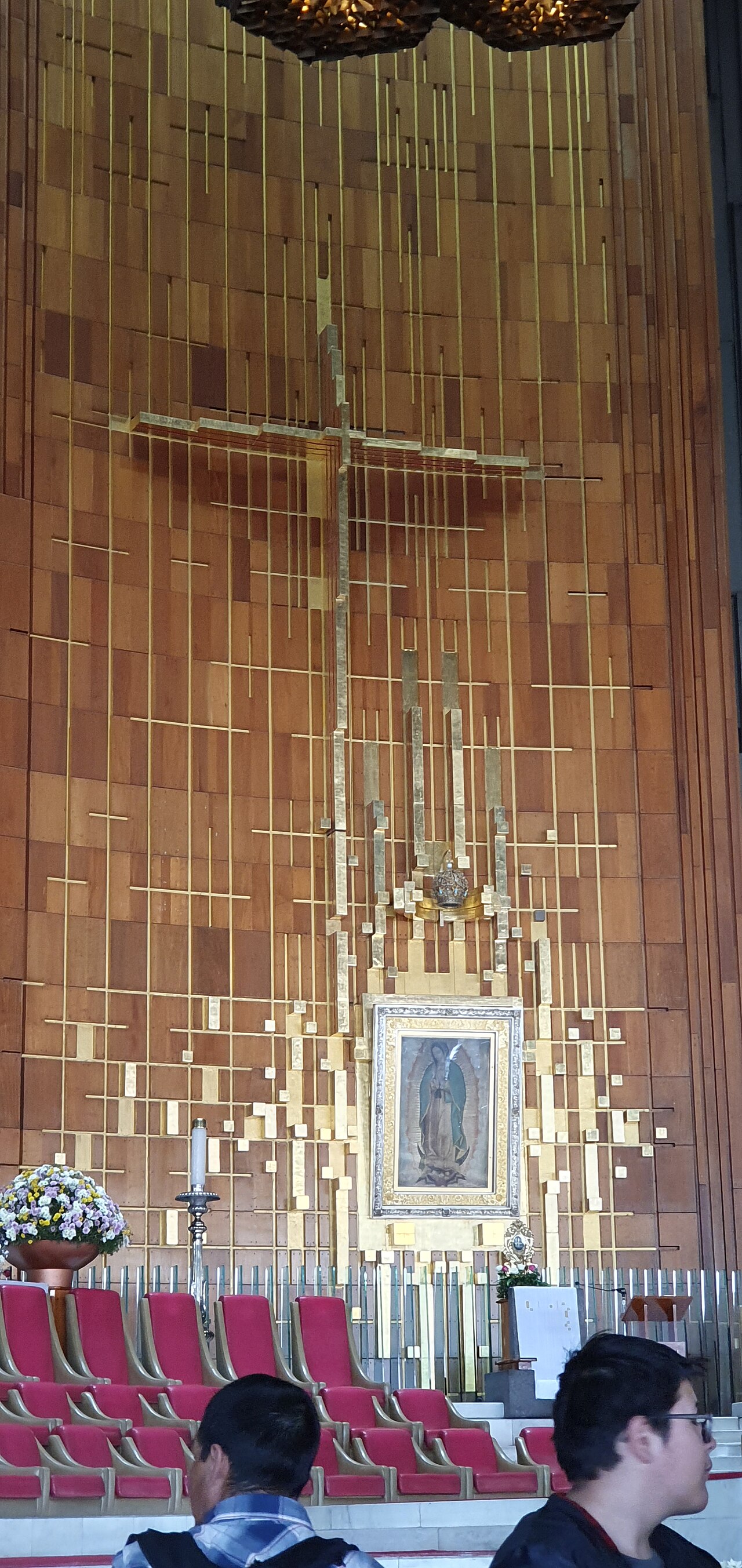 The tilma of St. Juan Diego framed beneath the cross on the gilded altar wall of the new basilica