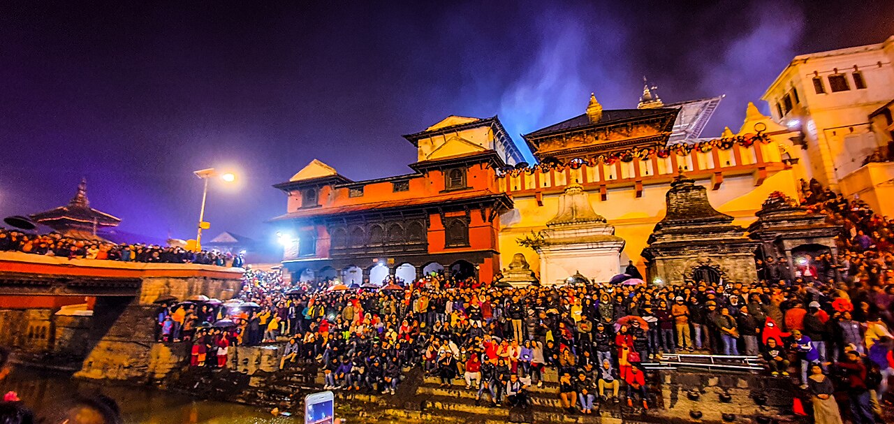 Devotees fill the east bank terraces of Pashupatinath on an evening of aarati