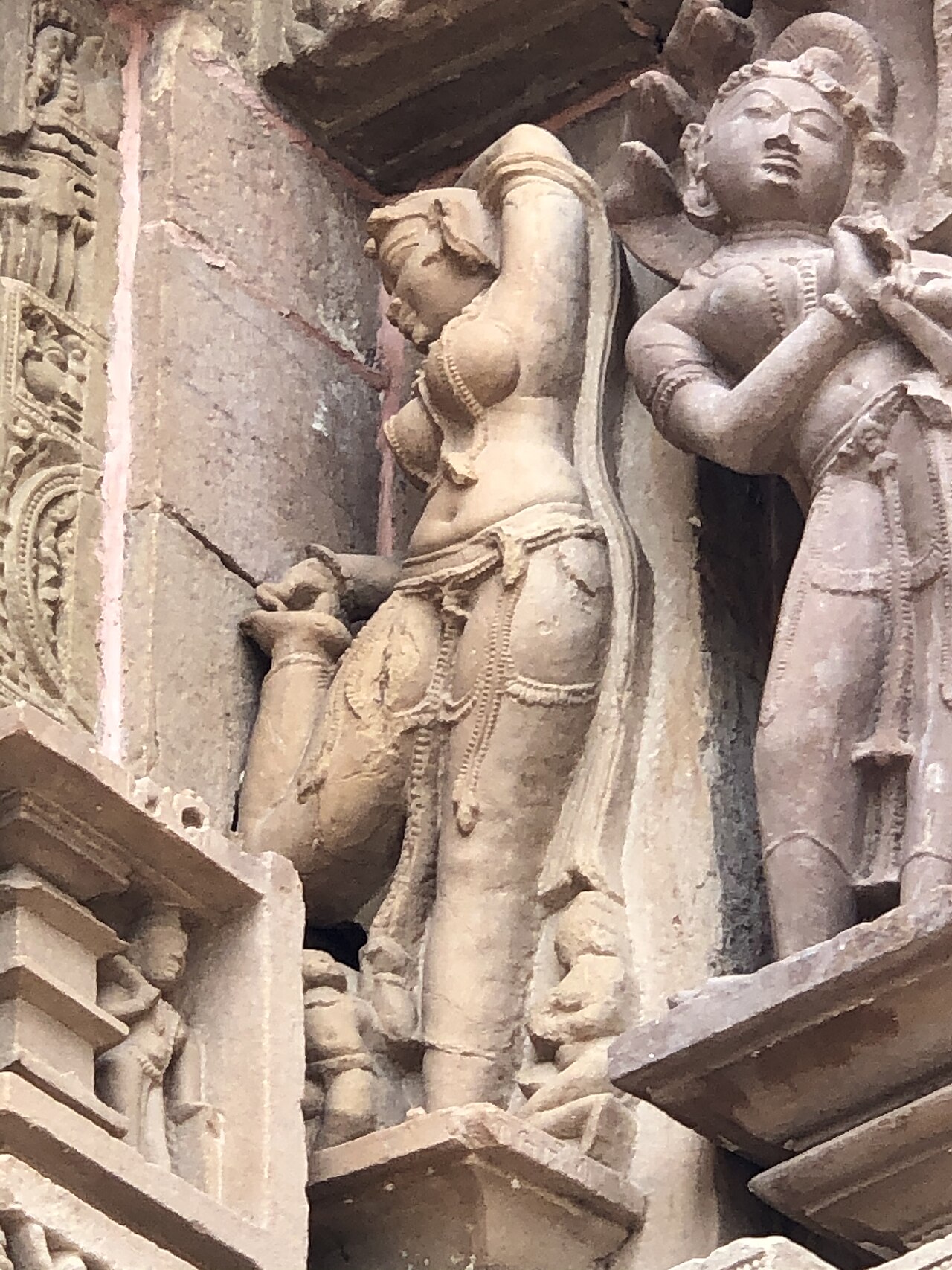 A carved sculpture band on the Kandariya Mahadeva temple wall showing a scene of daily life from the Chandela era