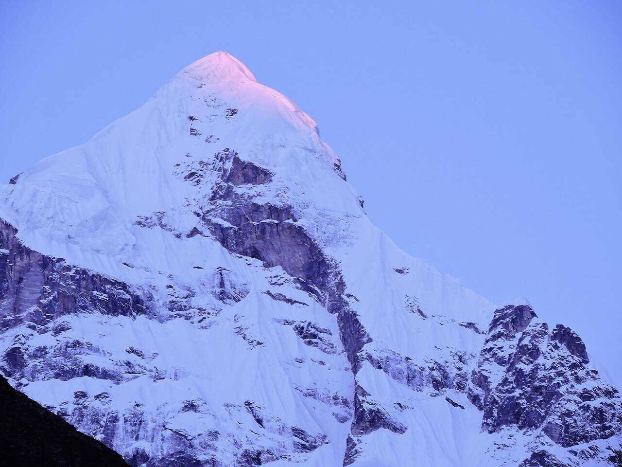 First sunlight on the snow pyramid of Neelkanth peak, seen from Badrinath