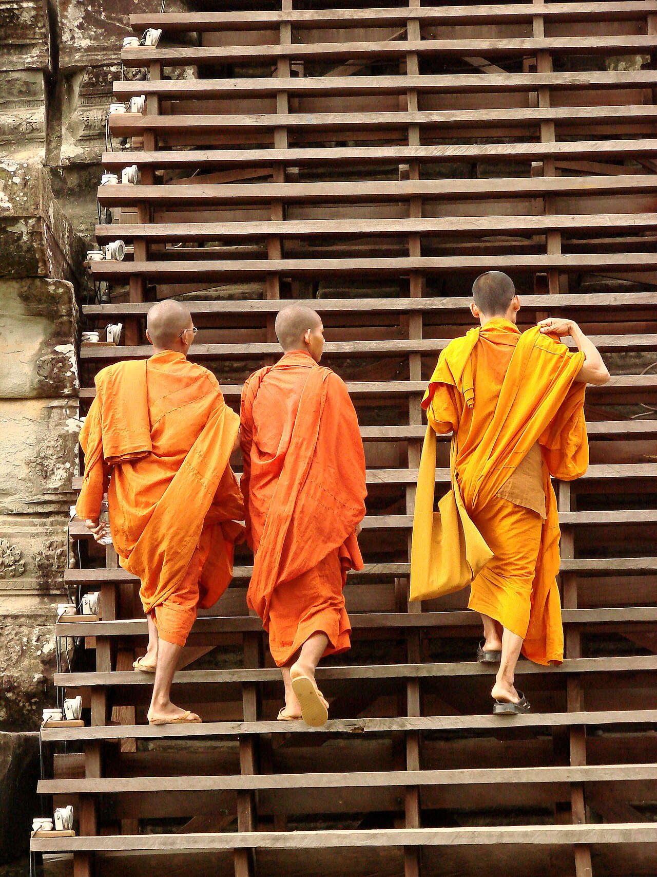 Buddhist monks in saffron robes walking at Angkor Wat