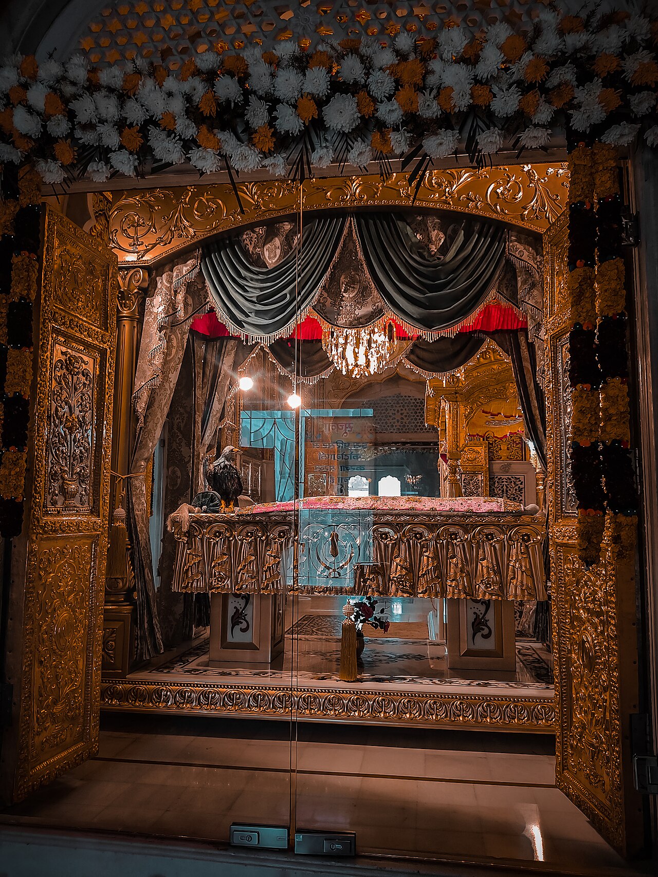 A preserved baaz, the hawk of Guru Gobind Singh Ji, displayed in a gilded case in the Takht's relic hall
