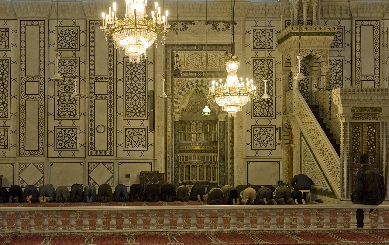 The prayer hall of the Umayyad Mosque near the mihrab, columns and carpets under the Dome of the Eagle