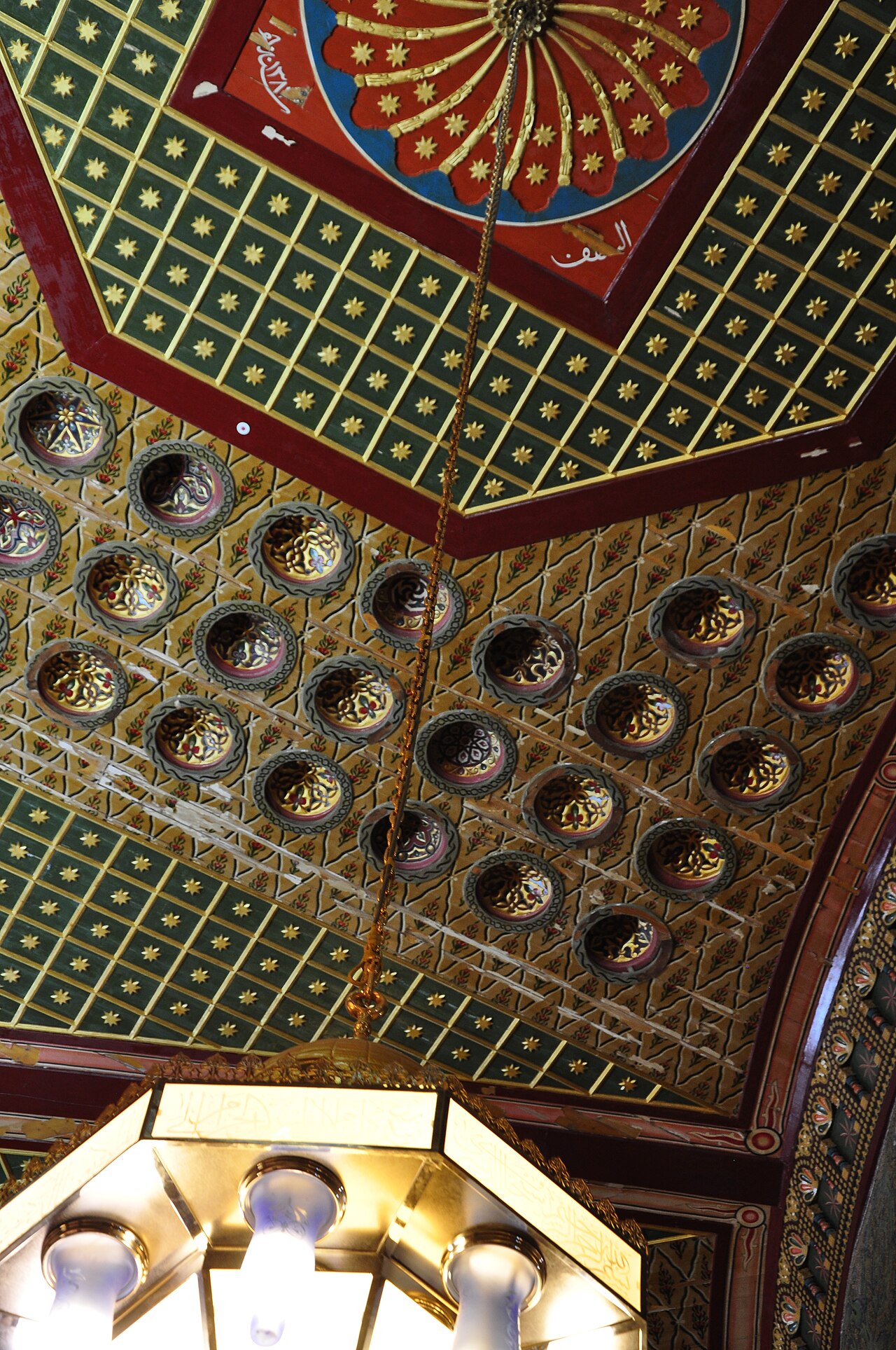 The painted and gilded interior of the dome, rising directly above the Foundation Stone