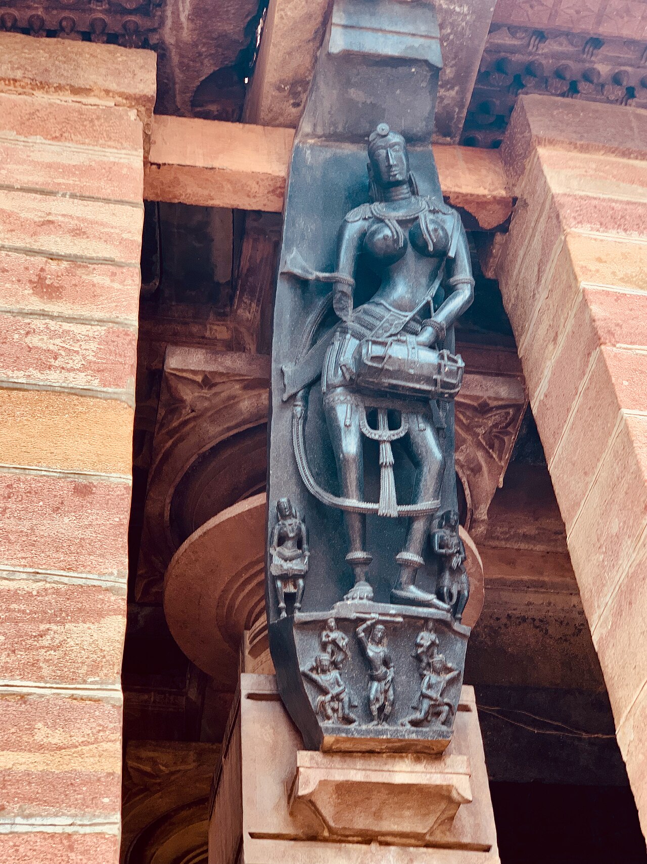 A black basalt bracket figure of a drummer carved at a pillar-top of the Ramappa Temple, one of its Kakatiya madanikas