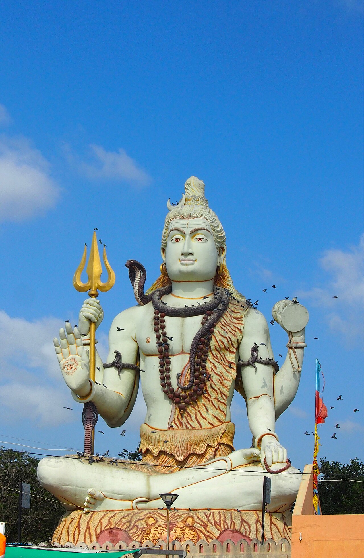 The 25 metre seated statue of Lord Shiva at Nageshwar, birds circling the golden trishul