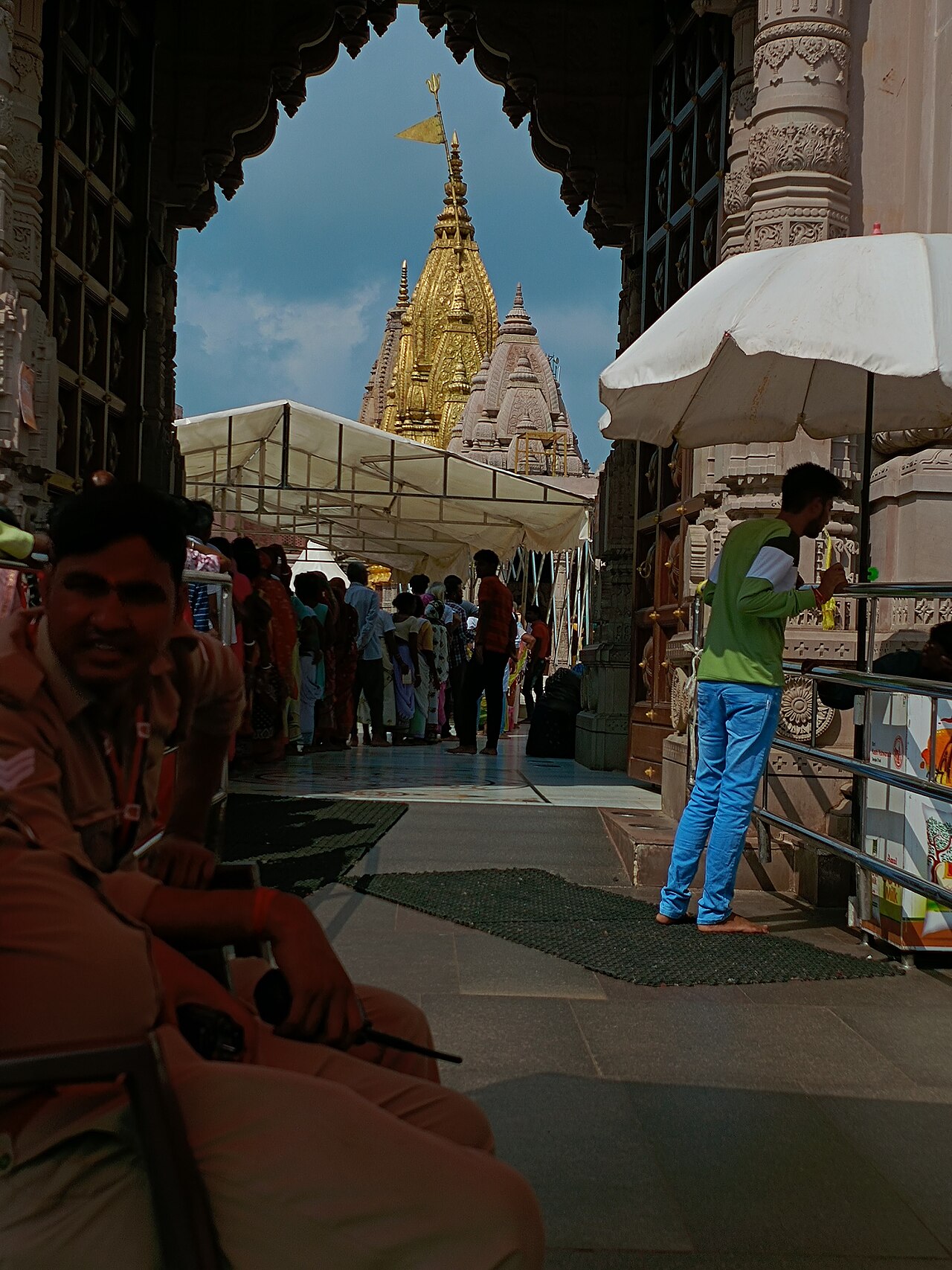 Pilgrims in the darshan line beneath the gold shikhara of Baba Vishwanath