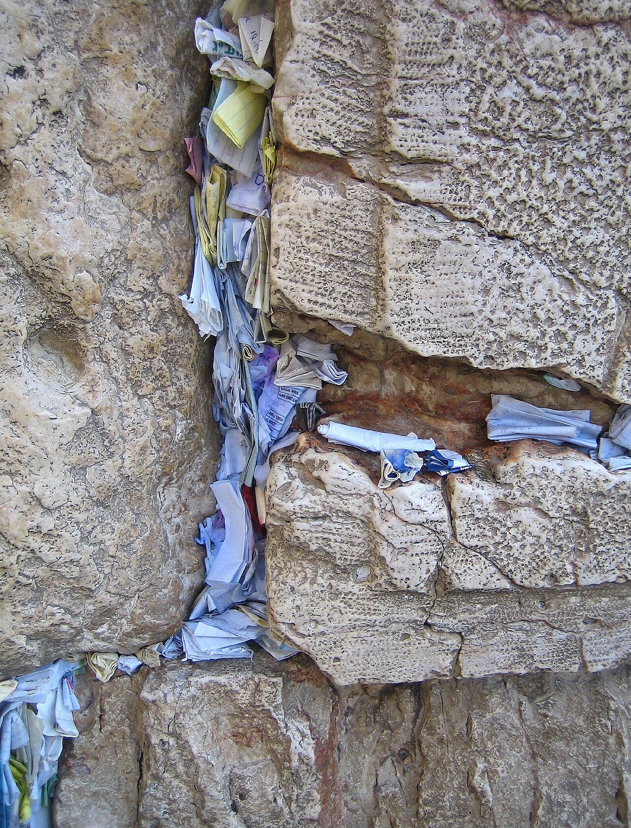 Kvitlach, folded prayer notes, pressed into the cracks between the stones of the Western Wall