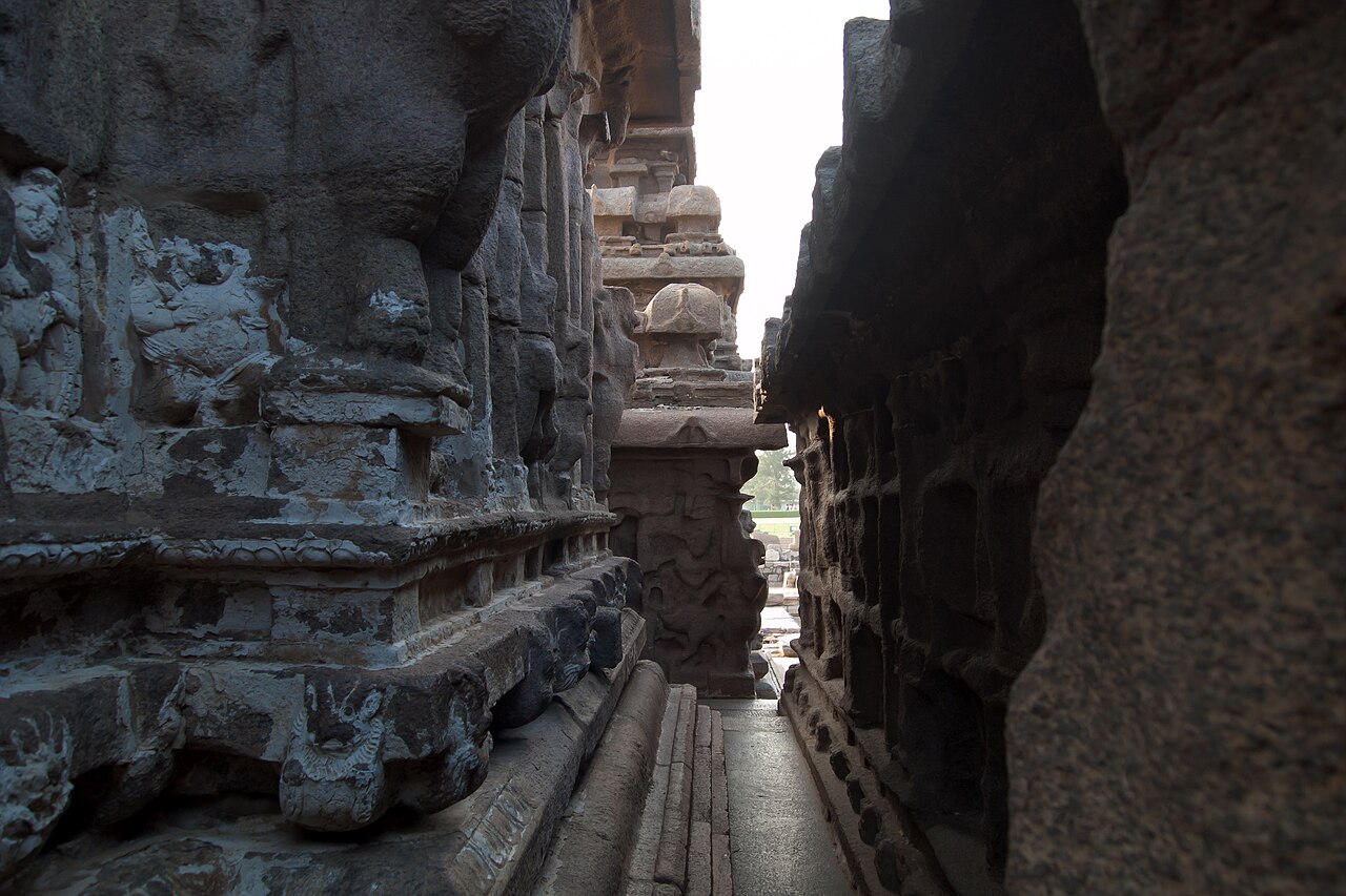 The narrow carved passage between the shrines of the Shore Temple, its granite reliefs softened by centuries of sea air