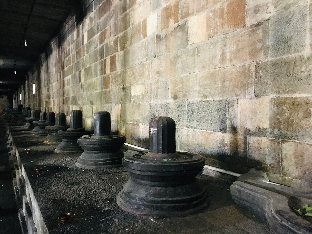 A row of stone Shivalingams along a corridor wall inside Ekambareswarar Temple, Kanchipuram
