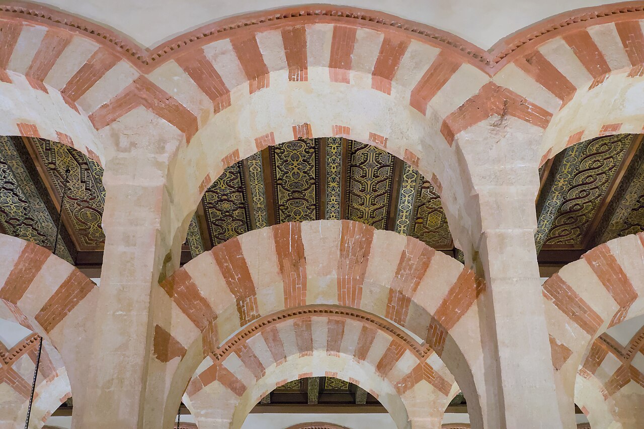 Double horseshoe arches of red brick and white stone inside the Mosque-Cathedral of Córdoba