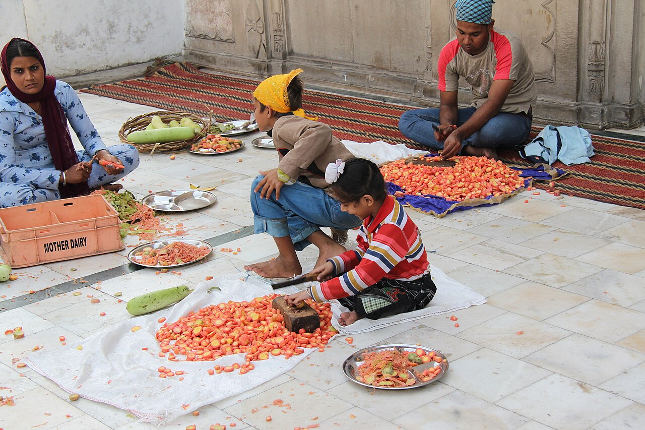 Sangat at Gurdwara Sis Ganj Sahib preparing vegetables together for the langar kitchen