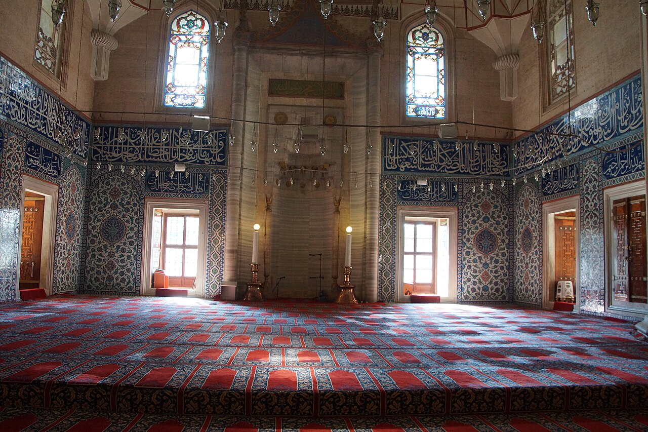 Worshippers and visitors in the single vast prayer hall of the Selimiye Mosque beneath Sinan's dome