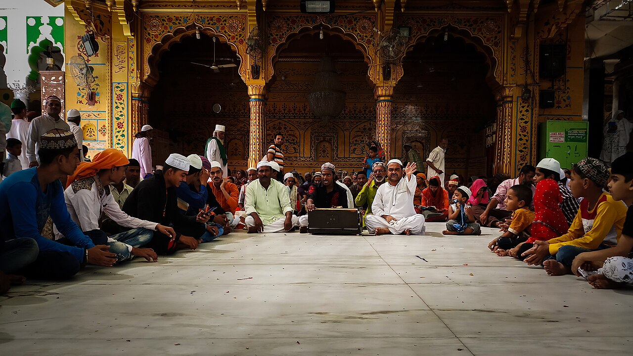 Qawwals with harmonium singing before pilgrims seated in a courtyard of the Ajmer Sharif Dargah