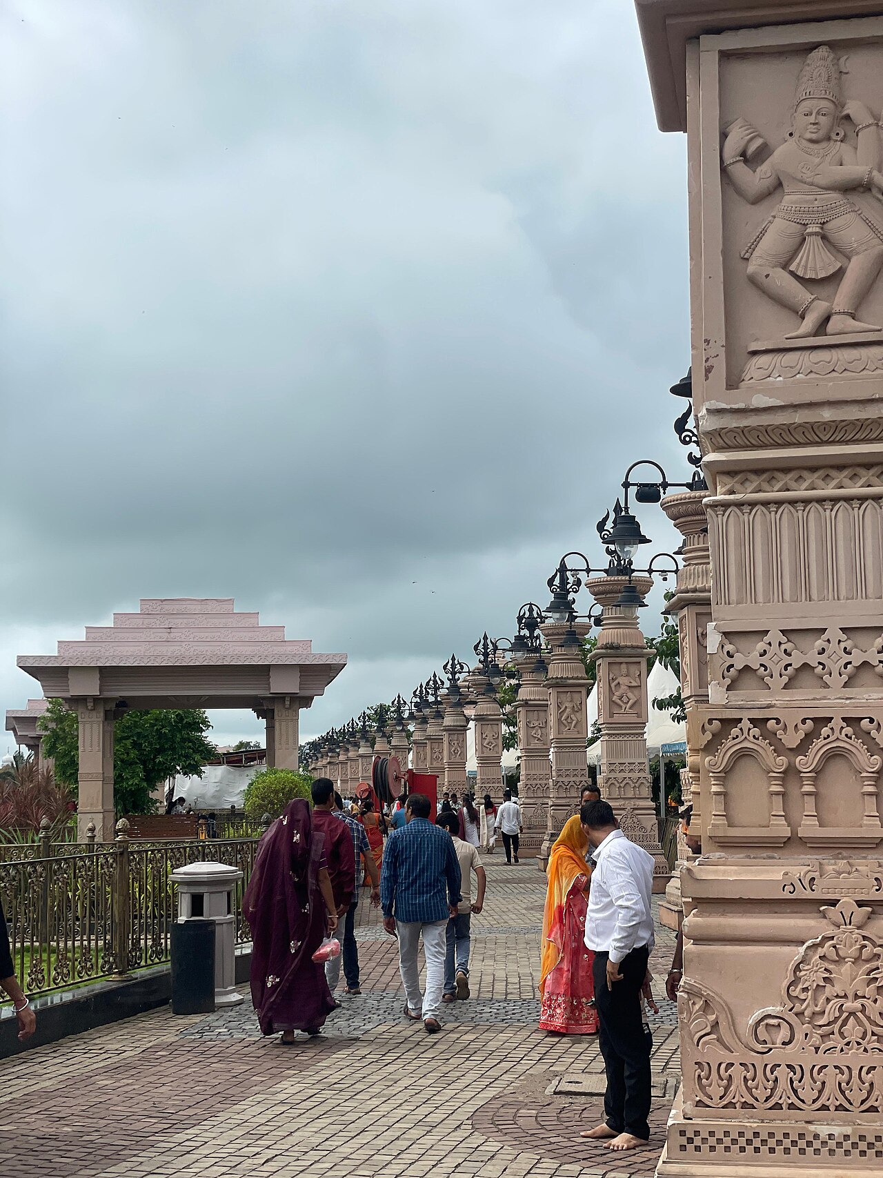 Pilgrims walking the Mahakal Lok corridor past its carved sandstone pillars in Ujjain