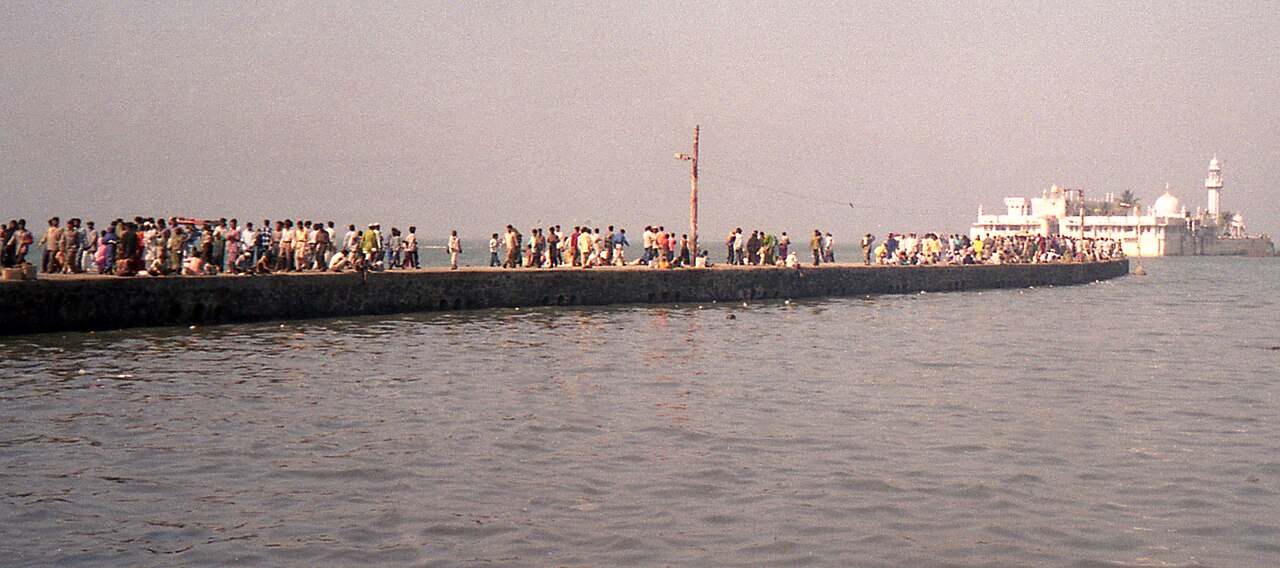Pilgrims streaming both ways along the causeway to Haji Ali Dargah, the white shrine and minaret rising from the sea beyond