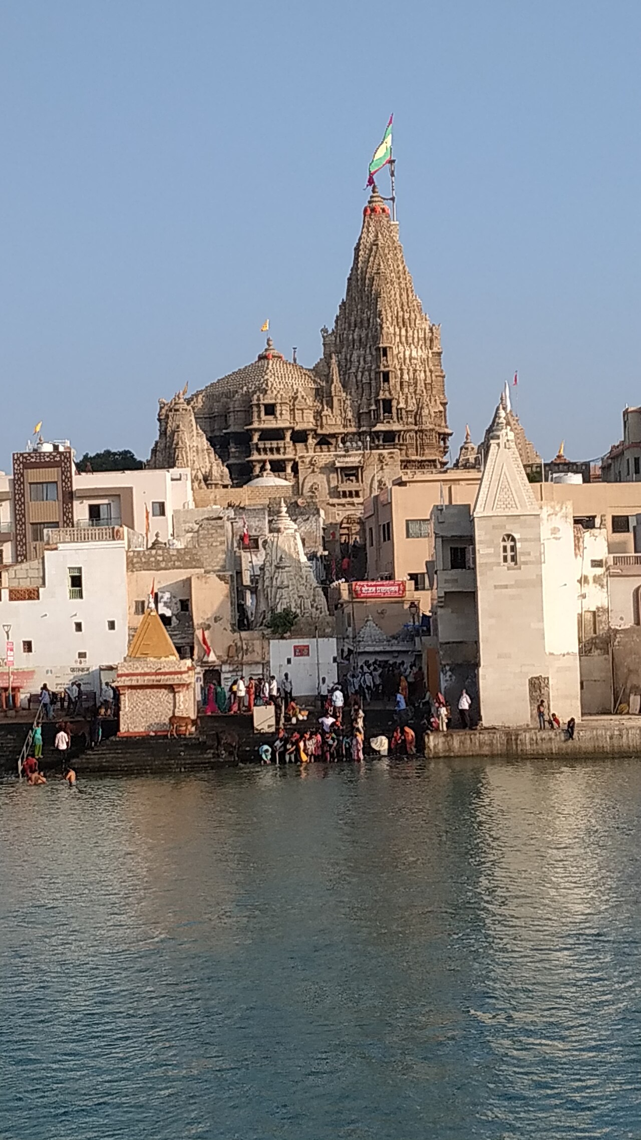 The Dwarkadhish temple rising above pilgrims bathing at the Gomti ghat