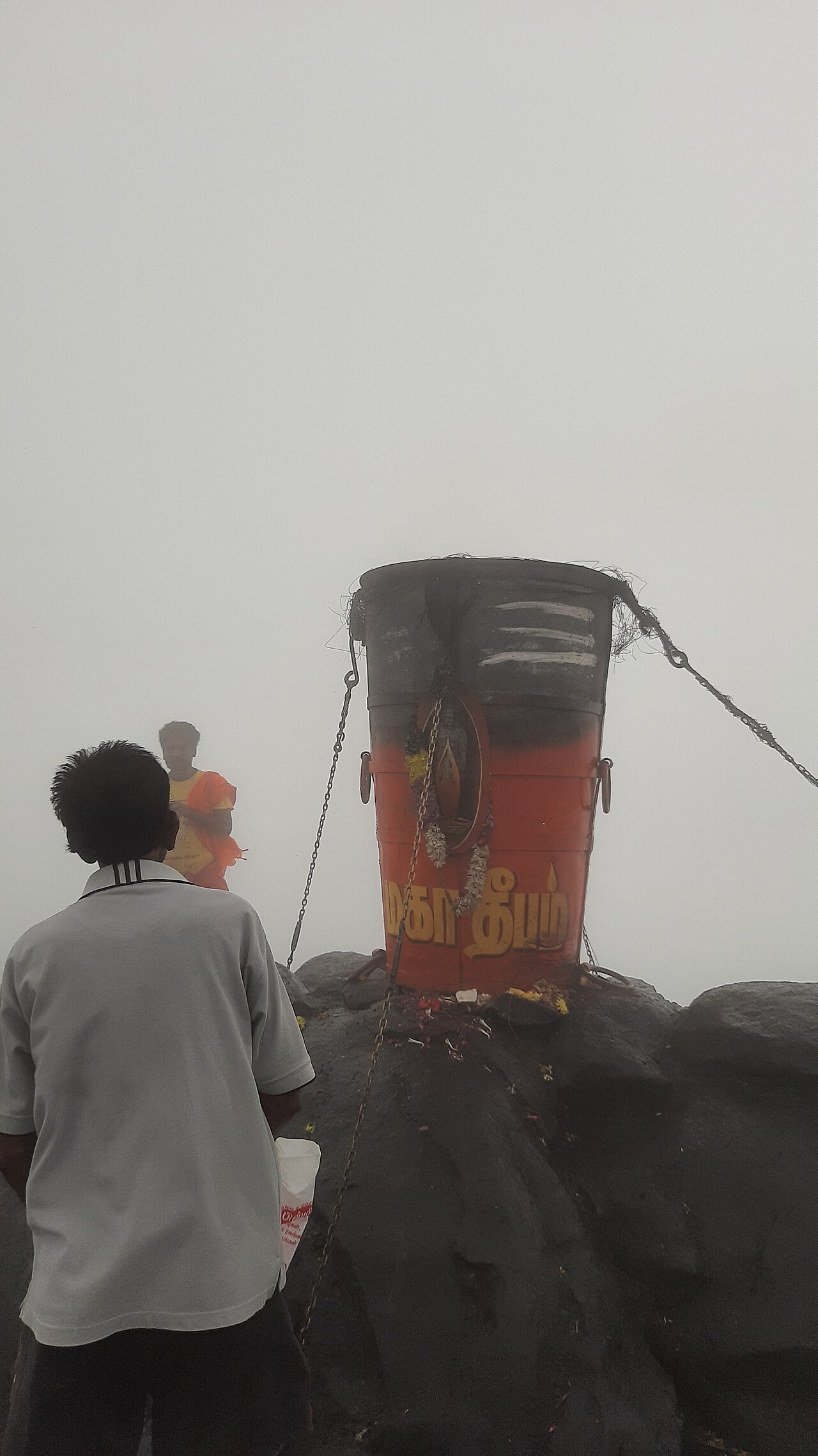 The Karthigai Maha Deepam flame burning at the summit of Arunachala hill at dusk