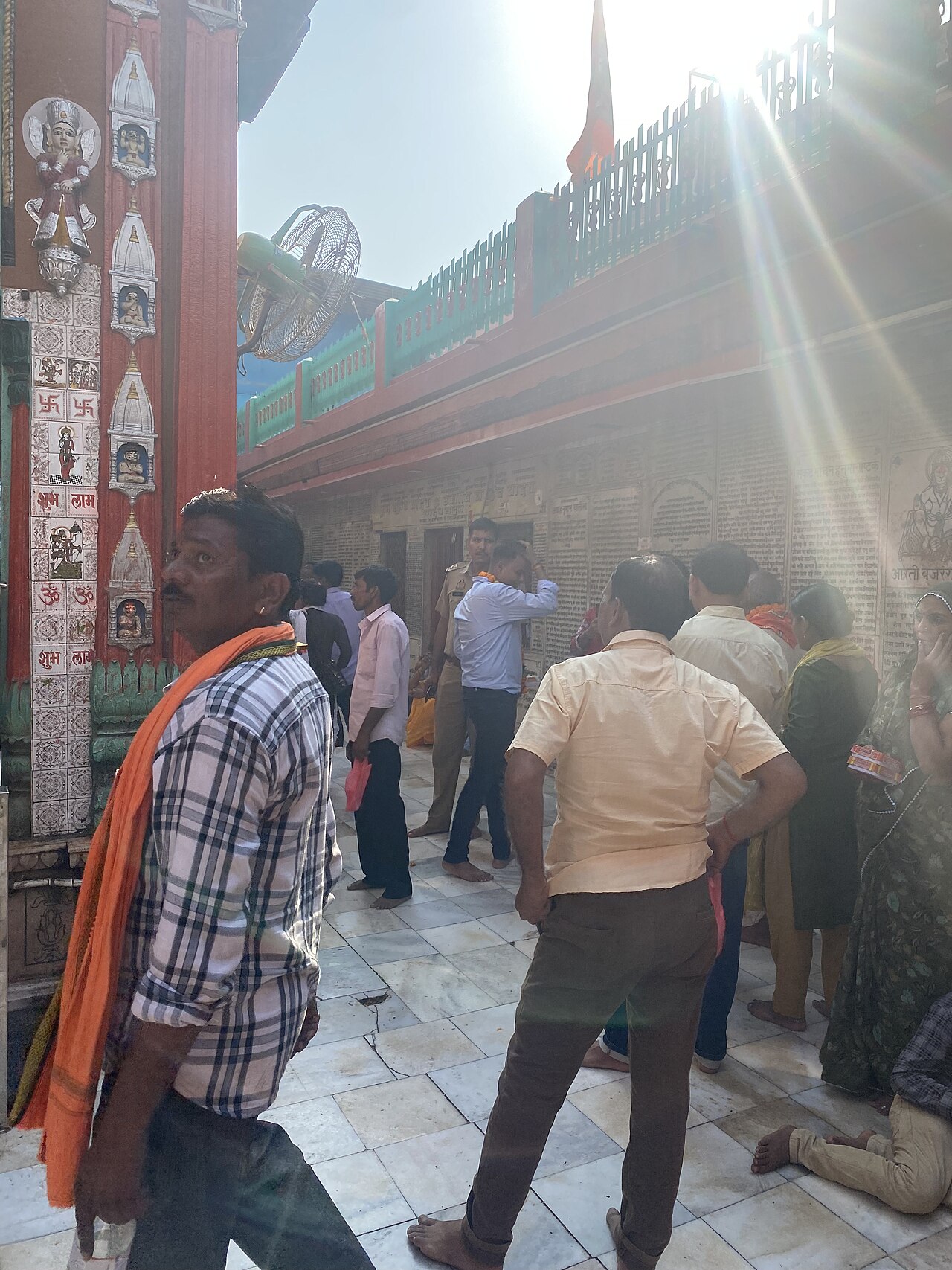 Pilgrims in the marble courtyard of Hanuman Garhi, its walls engraved with prayers